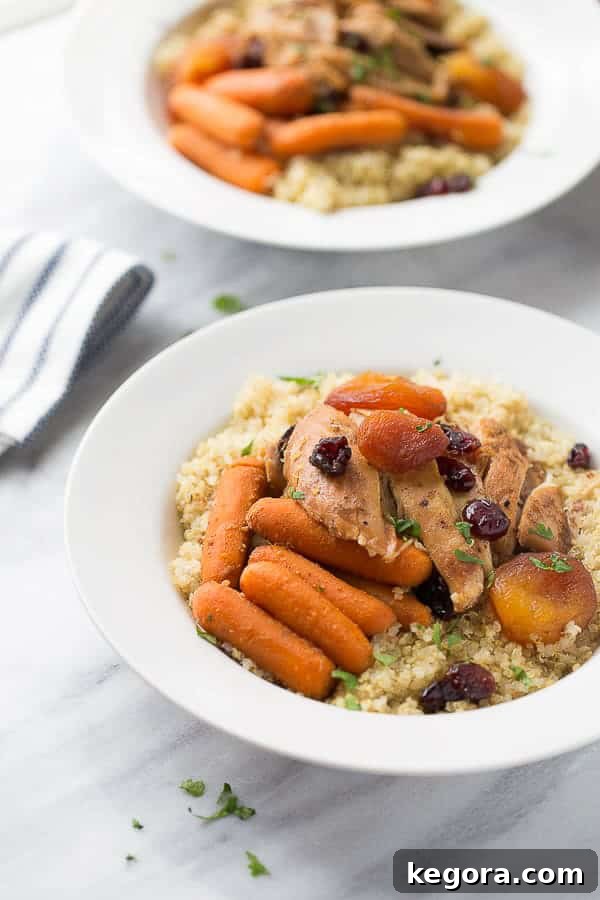 Slow-Cooker Moroccan Chicken with Quinoa A stunning shot of Slow-Cooker Moroccan Chicken served over a bed of quinoa on a pristine white plate, garnished with fresh herbs.