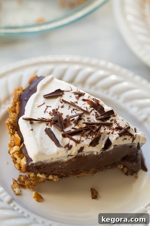 Gluten-Free Vegan Chocolate Pudding Pretzel Pie, topped with whipped cream and chocolate curls, on a rustic background.