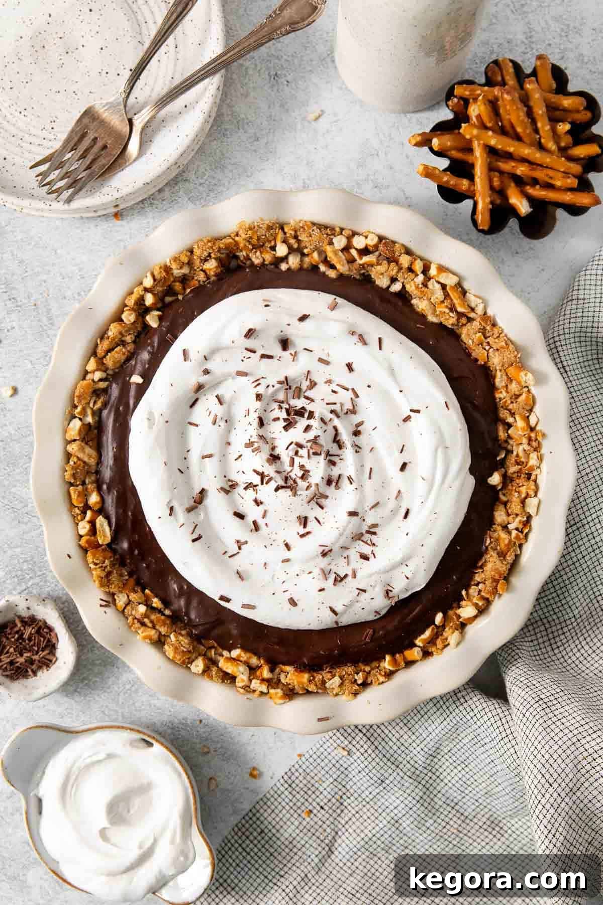 Overhead shot of gluten-free dairy free pie, garnished with chocolate curls, on a white background.