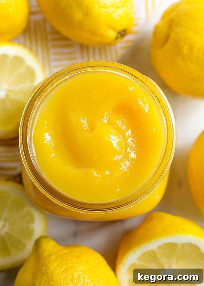 Top view of a small jar of Lemon Curd surrounded by cut lemons
