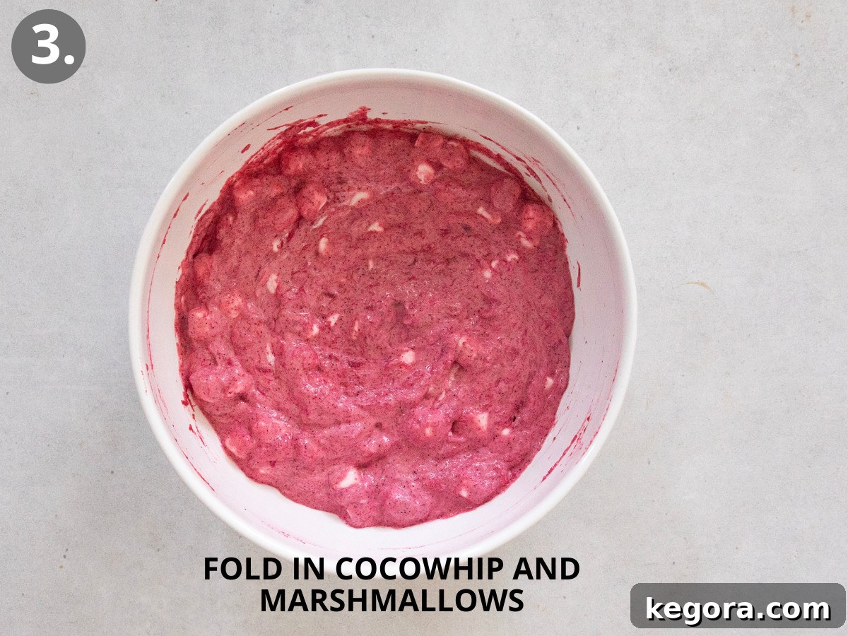 Vegan Cranberry Cloud 6 A large bowl of creamy dairy-free cranberry fluff, glistening and ready to be chilled, showcasing its appealing pink hue and soft texture.