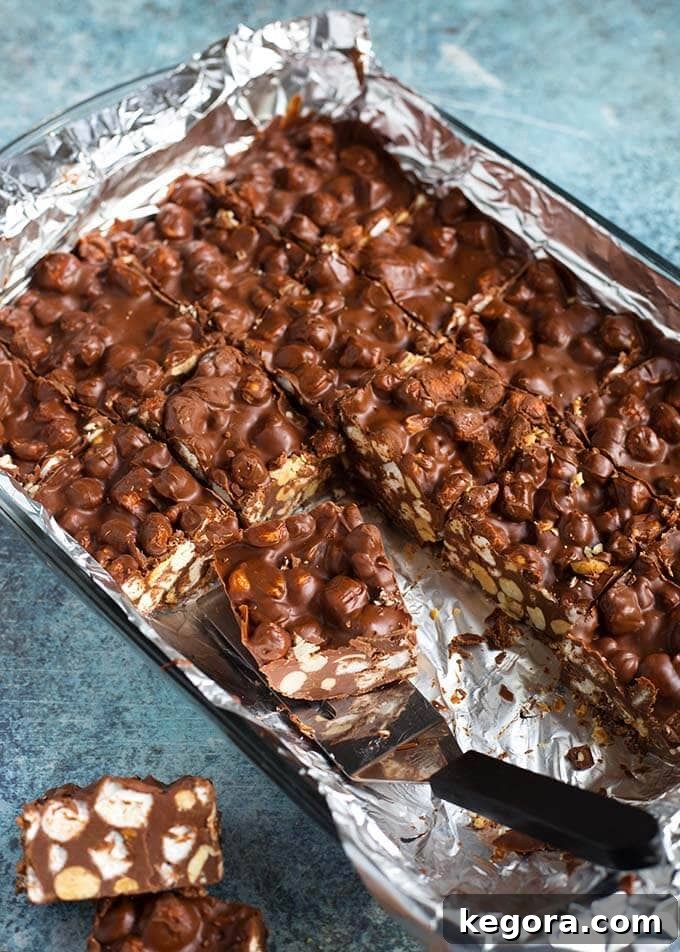 Decadent Chocolate Peanut Butter Bars 3 Foil-lined baking pan of 5 Ingredient Chocolate Peanut Bars with one being served with a silver spatula