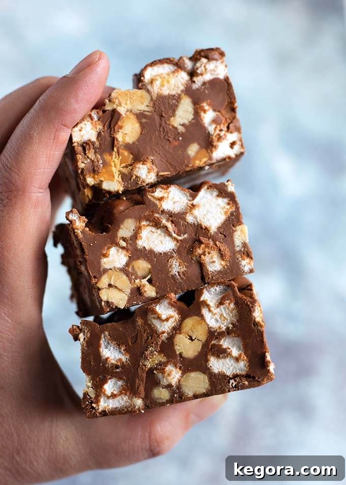 Decadent Chocolate Peanut Butter Bars 6 Closeup of hand holding a stack of three 5 Ingredient Chocolate Peanut Bars