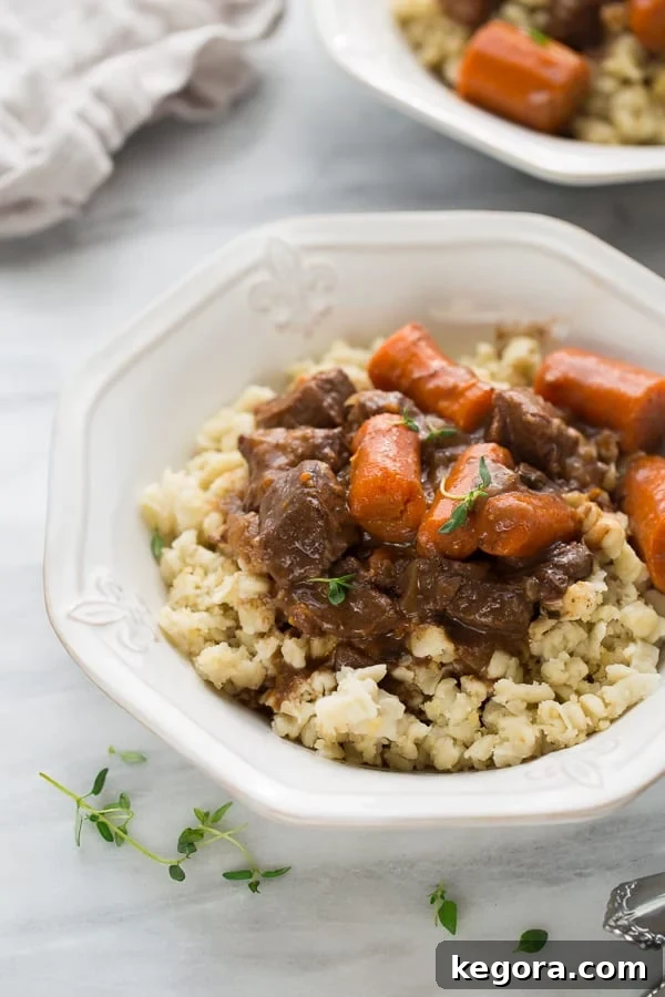 Gluten-Free German Spaetzle 4 Hearty Beef Burgundy served over a bed of golden Gluten-Free Spaetzle in a white bowl, ready for a comforting meal.