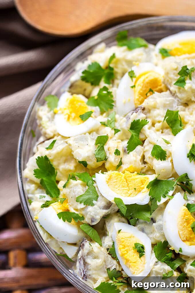 Classic Potato Salad served in a clear glass bowl, showcasing its creamy texture and fresh ingredients.