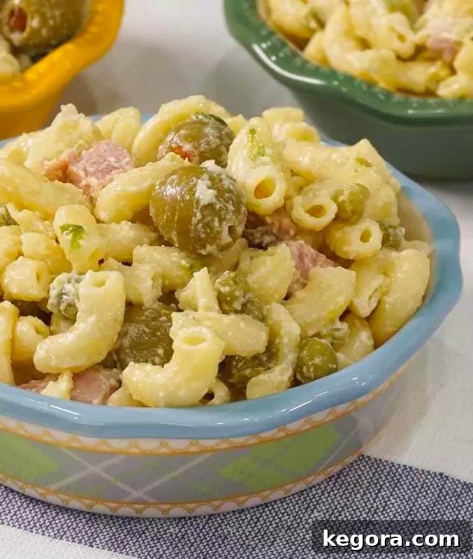 Creamy macaroni salad served in a decorative blue patterned bowl, highlighting its vibrant ingredients.