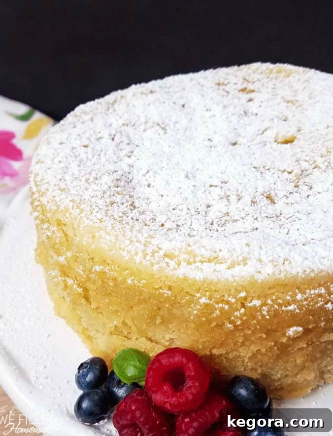 A slice of Grandma's Instant Pot Pound Cake served on a white plate with fresh berries, making a perfect summer dessert.