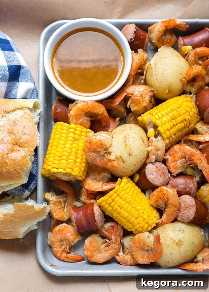 Low Country Shrimp Boil on a baking sheet, featuring perfectly cooked shrimp, corn on the cob, potatoes, and sausage.