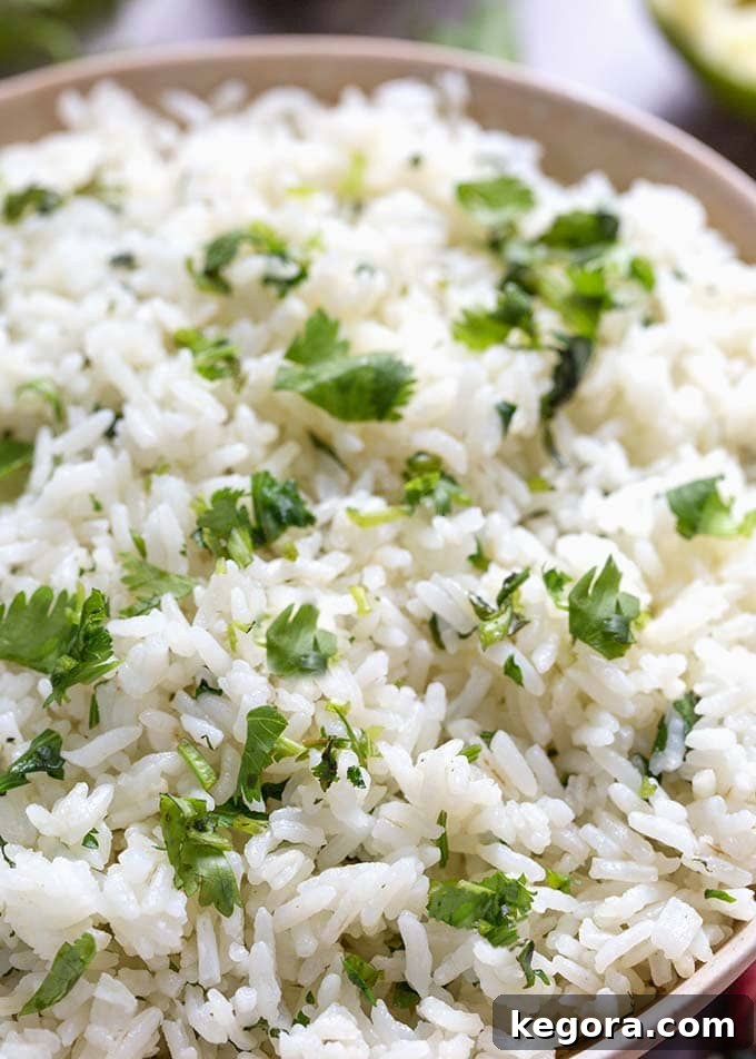 Closeup of fluffy Instant Pot Cilantro Lime Rice in a beige bowl, garnished with extra cilantro.