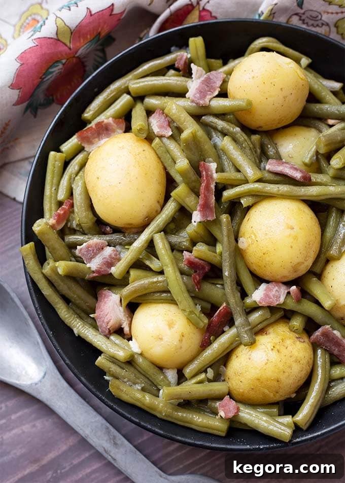 A black bowl filled with perfectly cooked Instant Pot Green Beans with New Potatoes and Bacon, a classic Southern comfort dish.