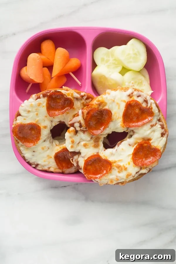 Pizza bagel with heart pepperoni on a pink plate for a Valentine's snack