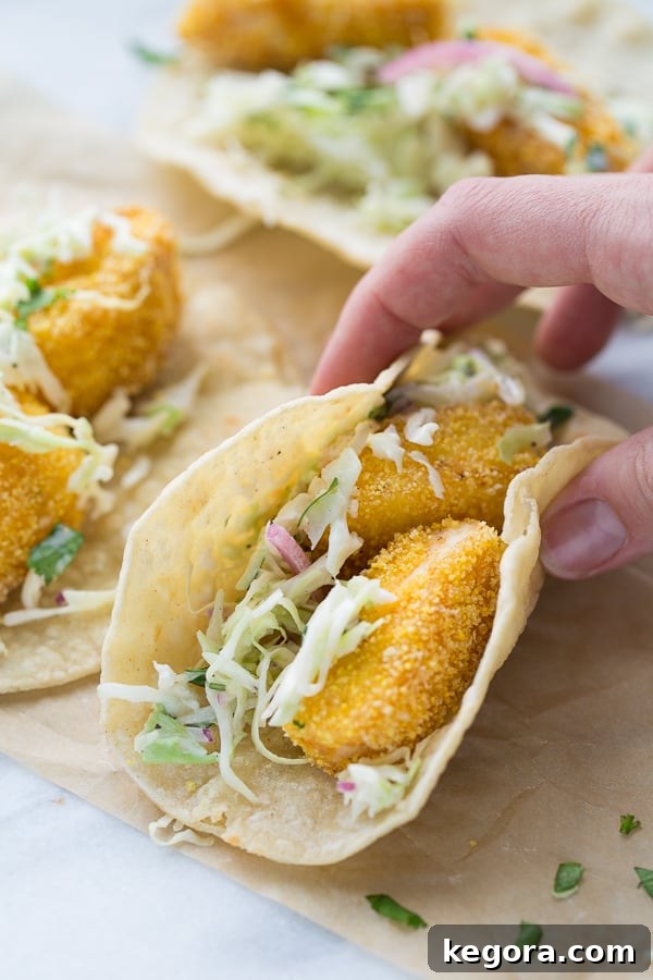 The Ultimate Gluten-Free Fish Tacos 5 A plate of assembled gluten-free fish tacos with a side of lime wedges and fresh cilantro.