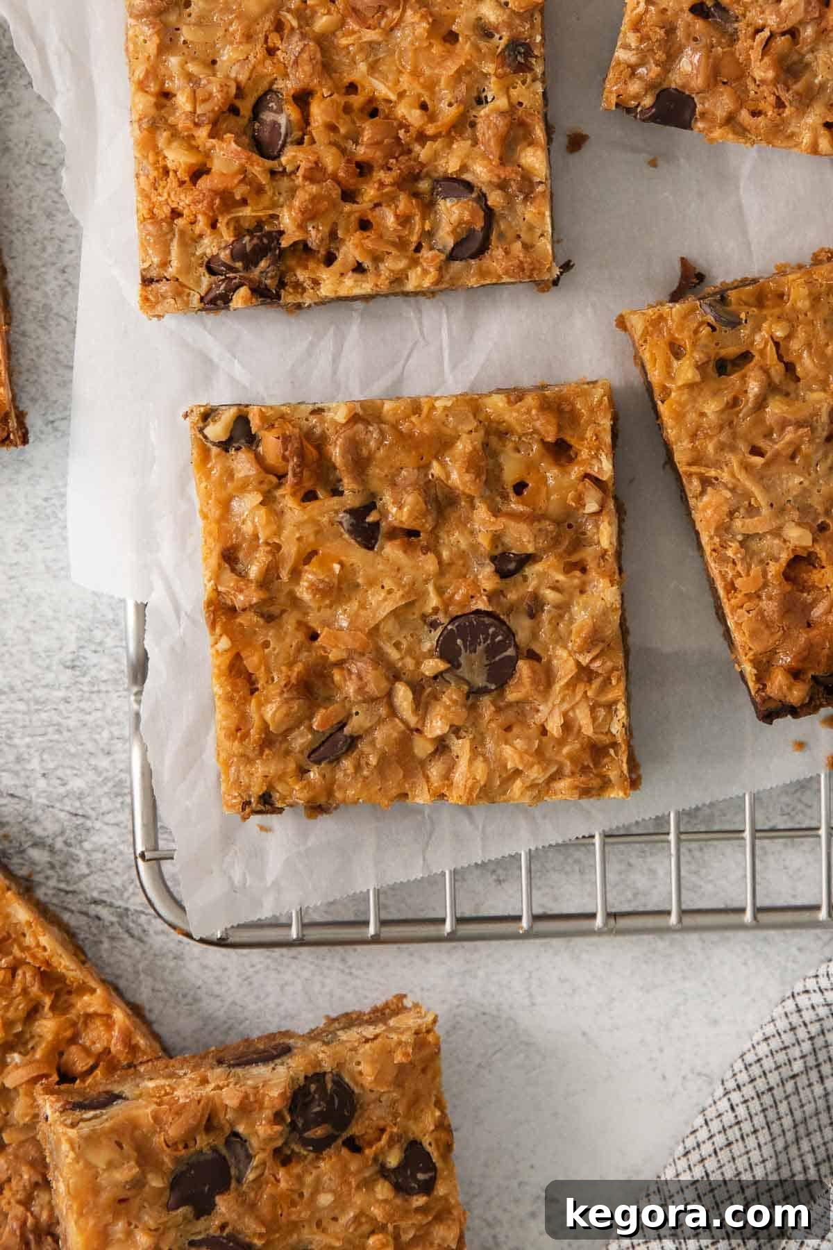 Gluten-Free Magic Bars 10 Perfectly cut 7-layer bars arranged on a cooling rack, showcasing their defined layers and readiness for enjoyment.