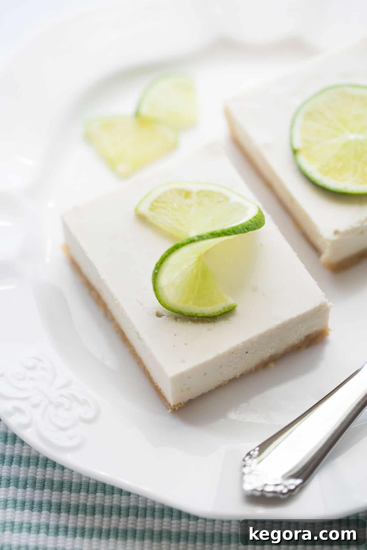 Vegan Key Lime Pie plated vegan key lime pie garnished with lime slices on white plate