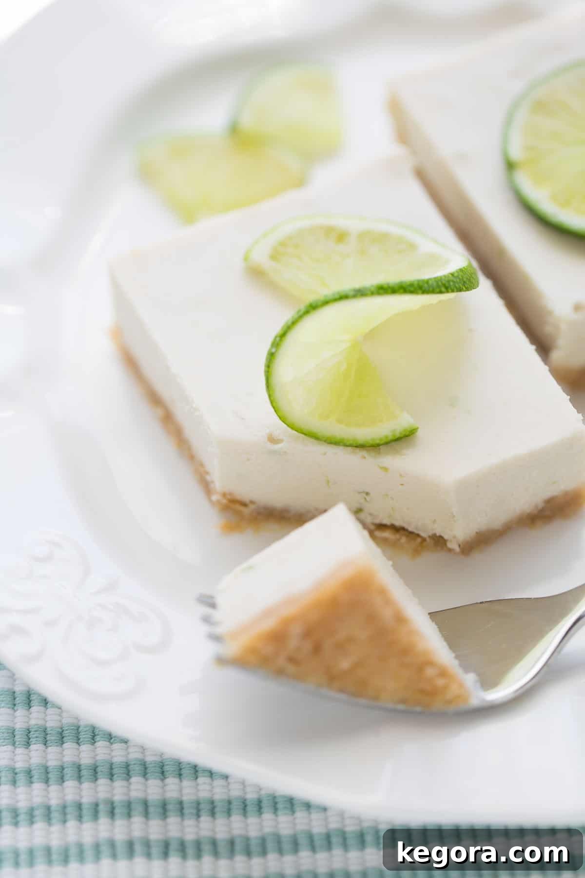 Vegan Key Lime Pie finished pie on white plate with fork taking bite