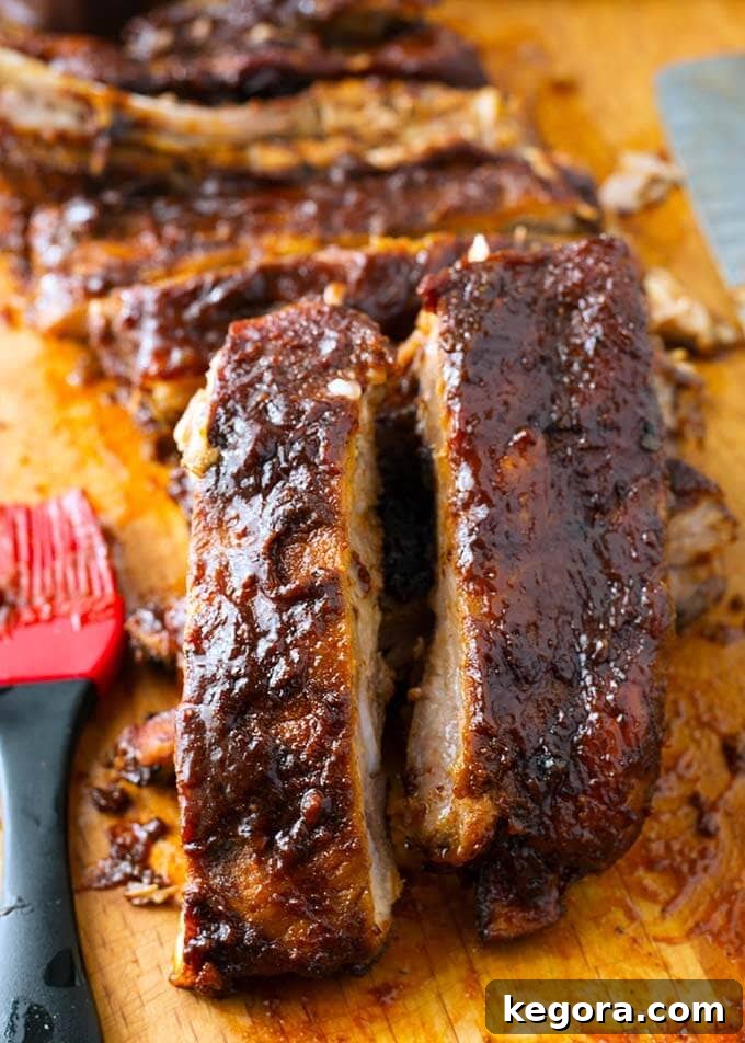 Close up of perfectly sliced, tender slow cooker Ribs on a wooden cutting board, ready to serve