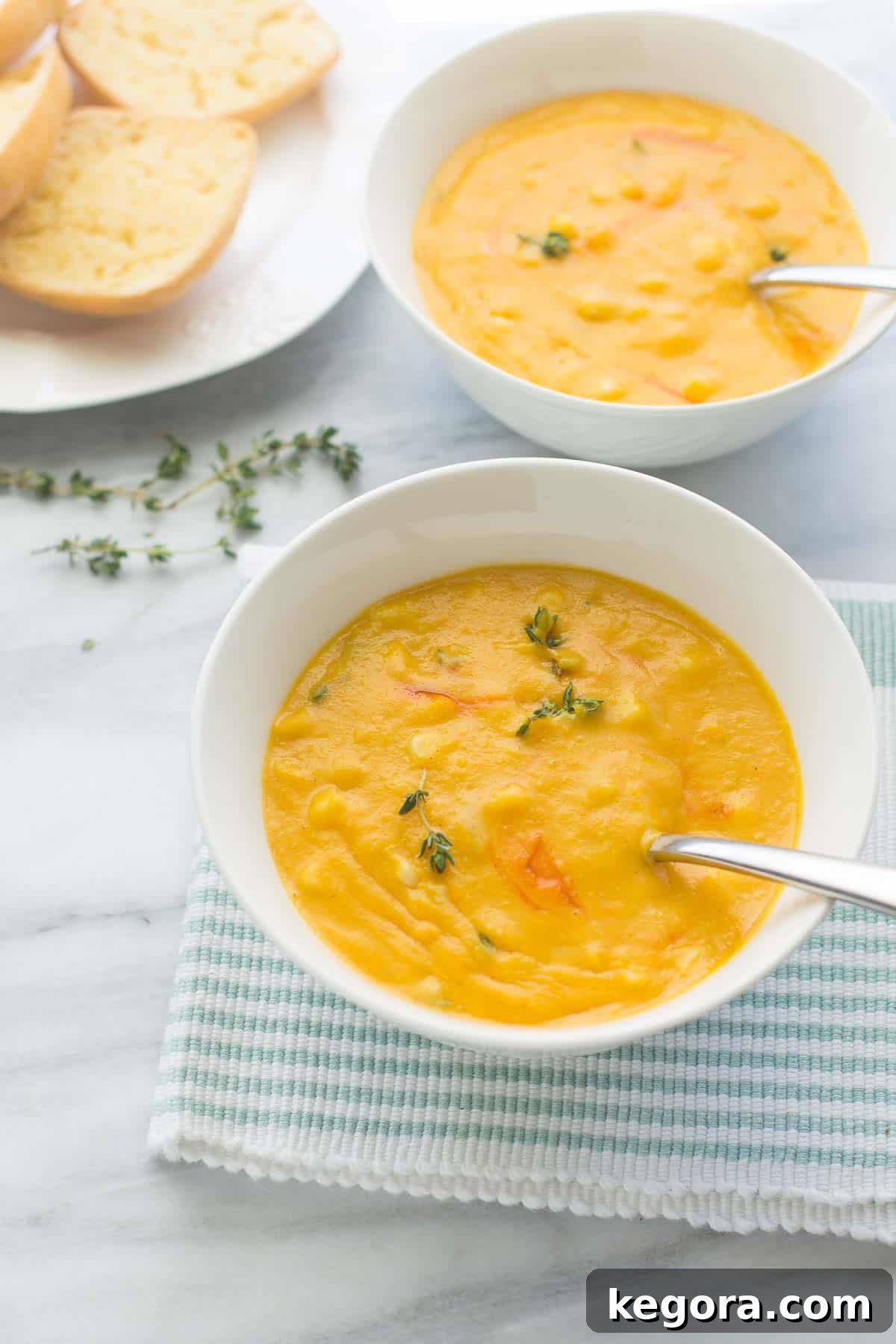 A comforting bowl of sweet corn soup, garnished and ready to be enjoyed with a spoon.