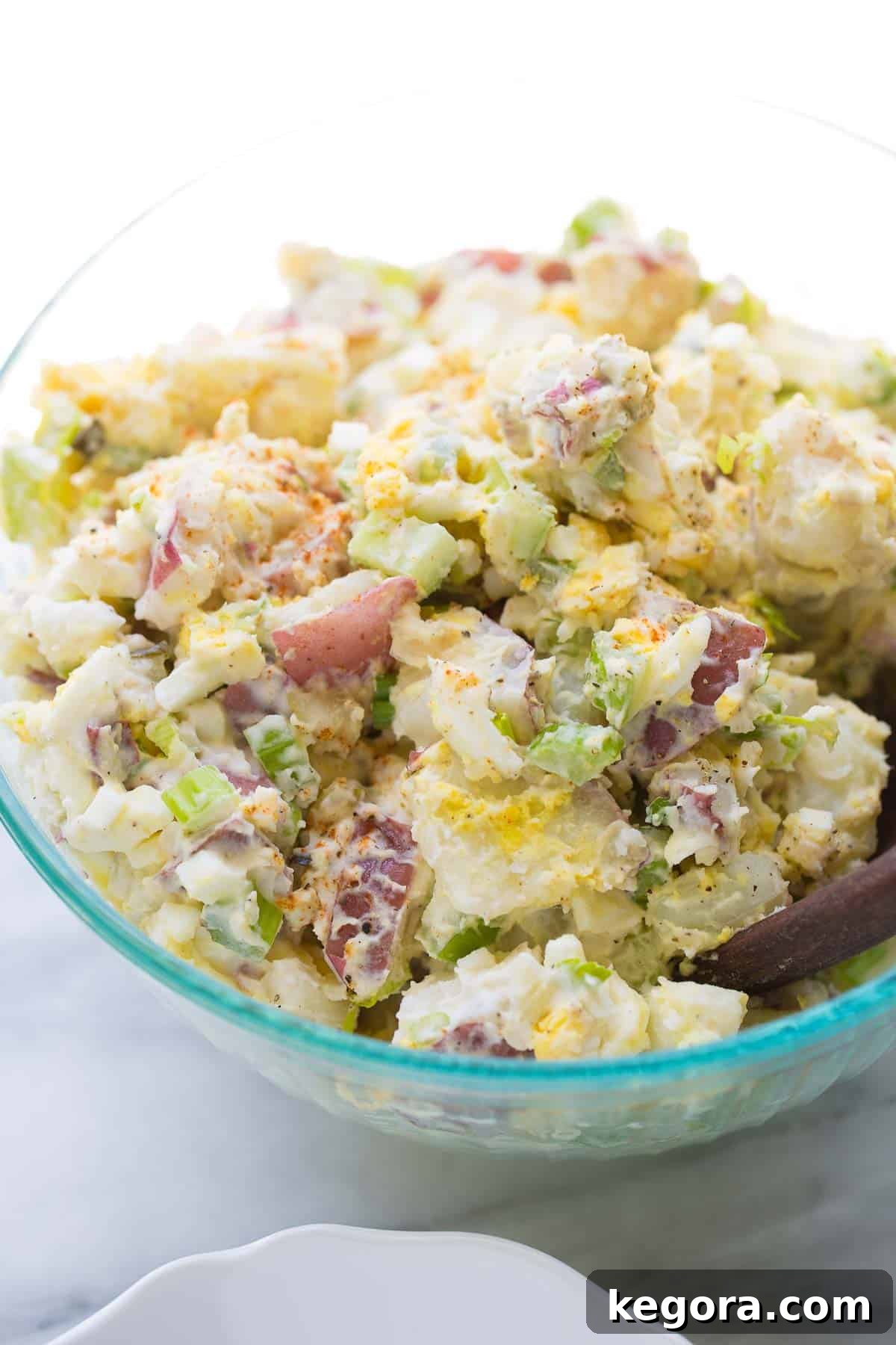 Best Creamy Potato Salad Large serving bowl full of the best creamy potato salad, garnished with fresh herbs, ready for a summer BBQ.
