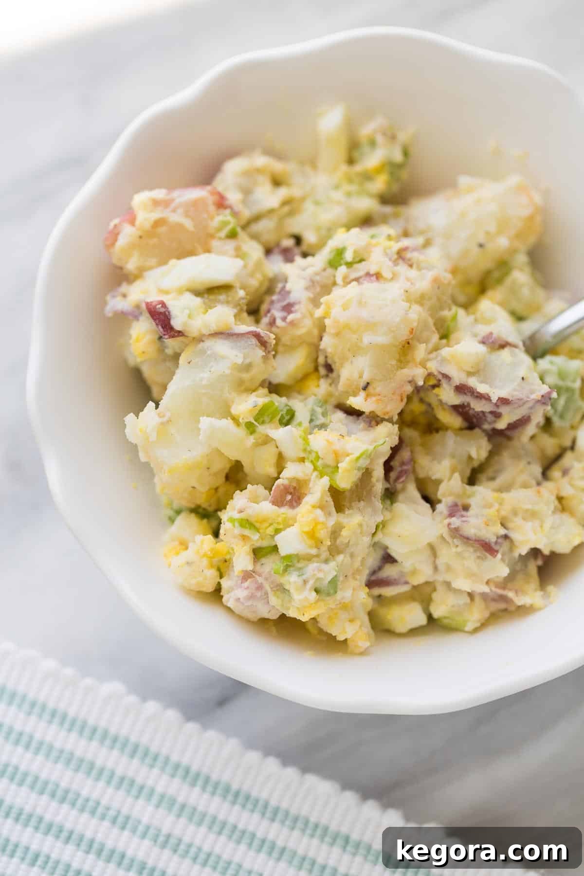 Potato Salad Creamy potato salad in a serving bowl with a fork, ready to be enjoyed.