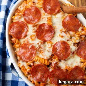 Pizza Pasta Casserole in a white oblong baking dish in front of a pressure cooker