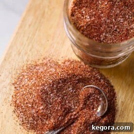 Homemade Baked Chicken Spice Rub in a small wooden bowl, prominently displayed on a rustic cutting board, ready to season poultry.