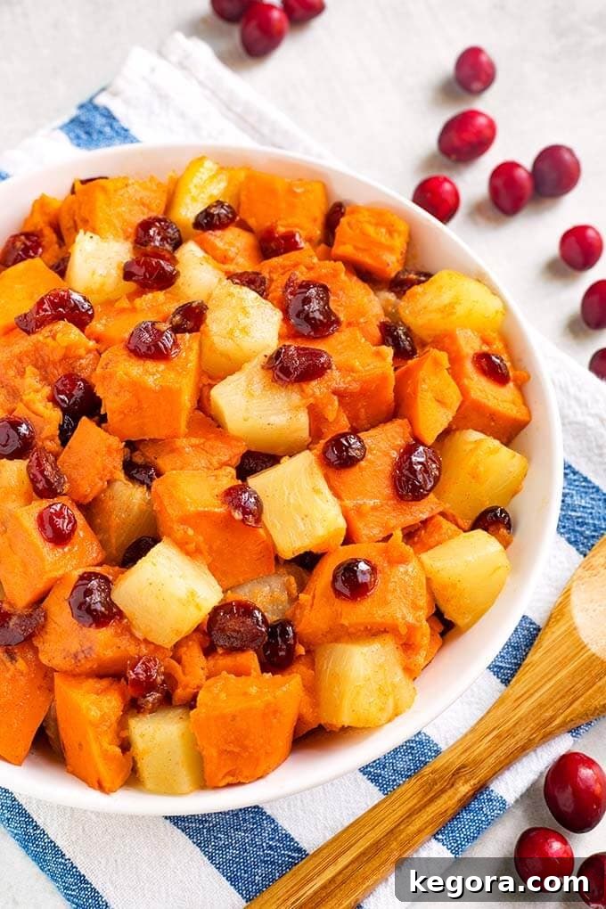 Sweet Potato Cranberry Casserole in a white bowl on a white and blue striped napkin