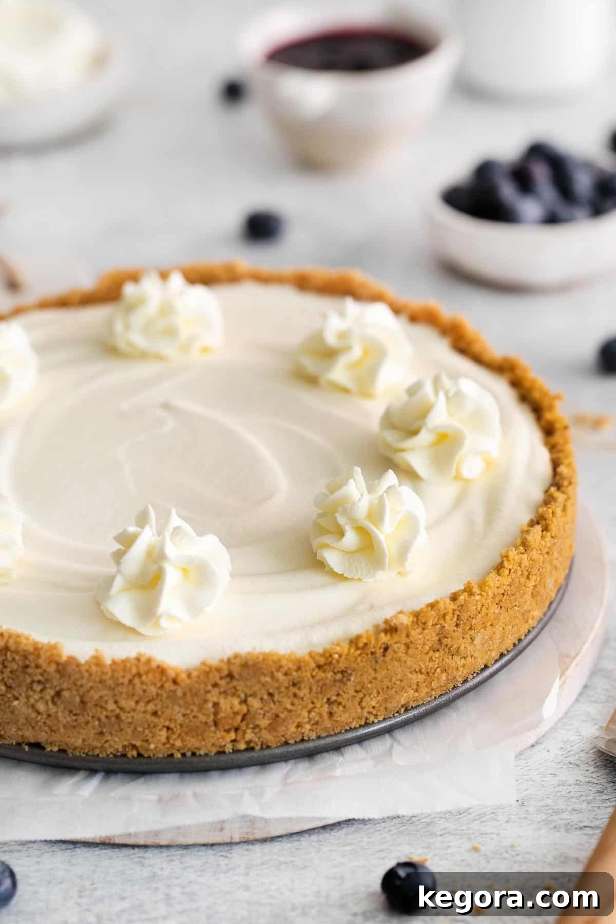 A whole gluten-free no-bake cheesecake on a serving dish, garnished lightly.