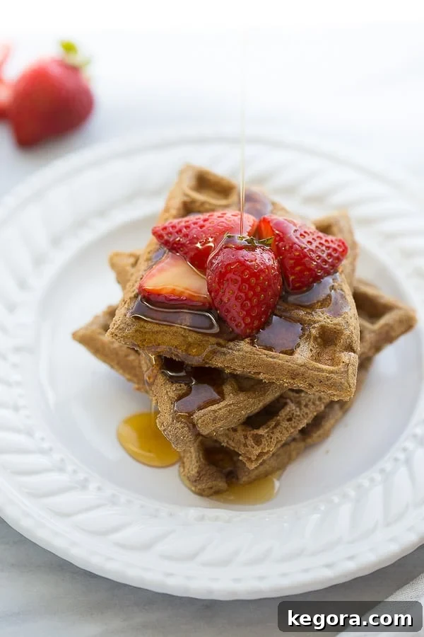 Buckwheat Waffles buckwheat waffles on white plate with strawberries and syrup