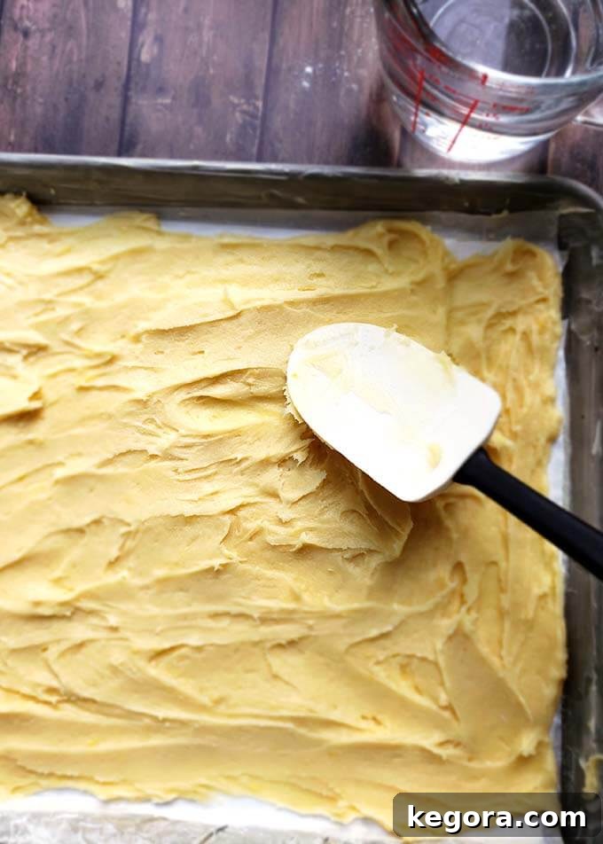 batter spread out on a baking sheet using a rubber spatula