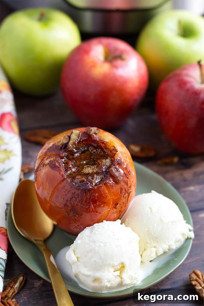 A single baked apple beautifully presented on a green plate, accompanied by two scoops of creamy vanilla ice cream and a golden spoon