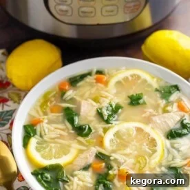 Lemon Chicken Orzo Soup in a white bowl in front of a pressure cooker is a light and delicious soup that you can make in minutes. This pressure cooker lemon chicken orzo soup is a healthy and simple Instant Pot chicken soup. simplyhappyfoodie.com #instantpotchickensoup #instantpotsoup #pressurecookerchickensoup