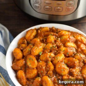 Hearty Instant Pot Sausage Gnocchi 6 Sausage Gnocchi in a white bowl in front of a pressure cooker