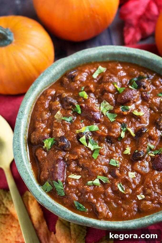 Cozy Instant Pot Pumpkin Chili 3 Pumpkin Chili in a turquoise bowl in front of two small pumpkins