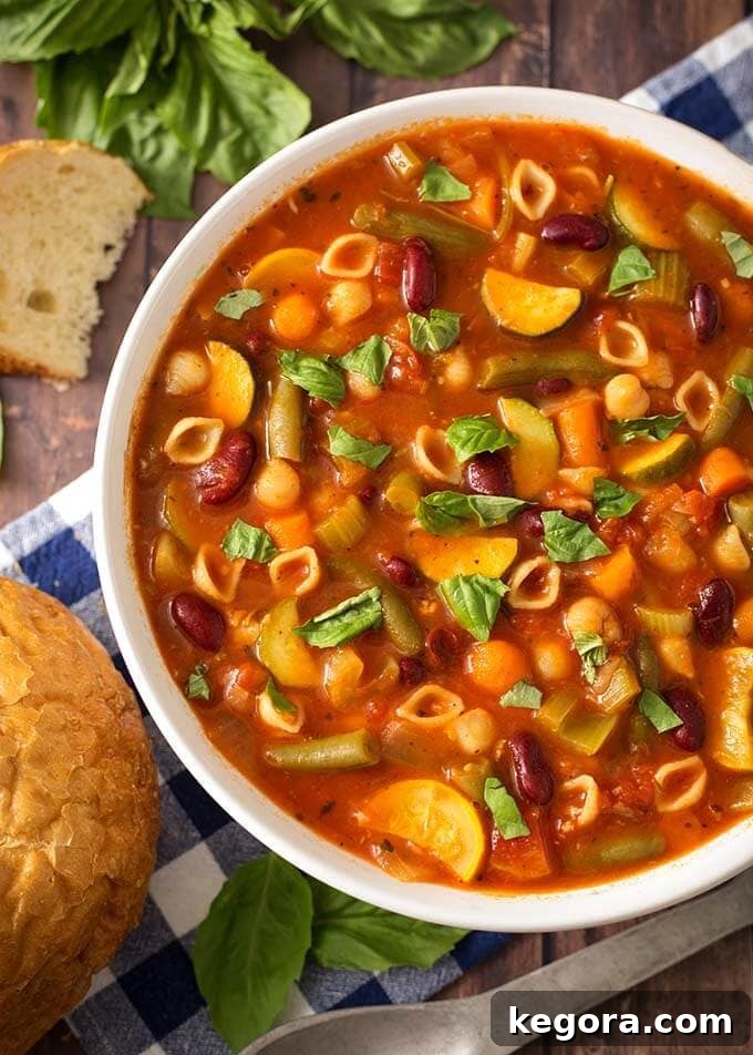 Effortless Instant Pot Minestrone Soup 7 Top view of Instant Pot Minestrone Soup in a white bowl garnished with fresh basil and Parmesan