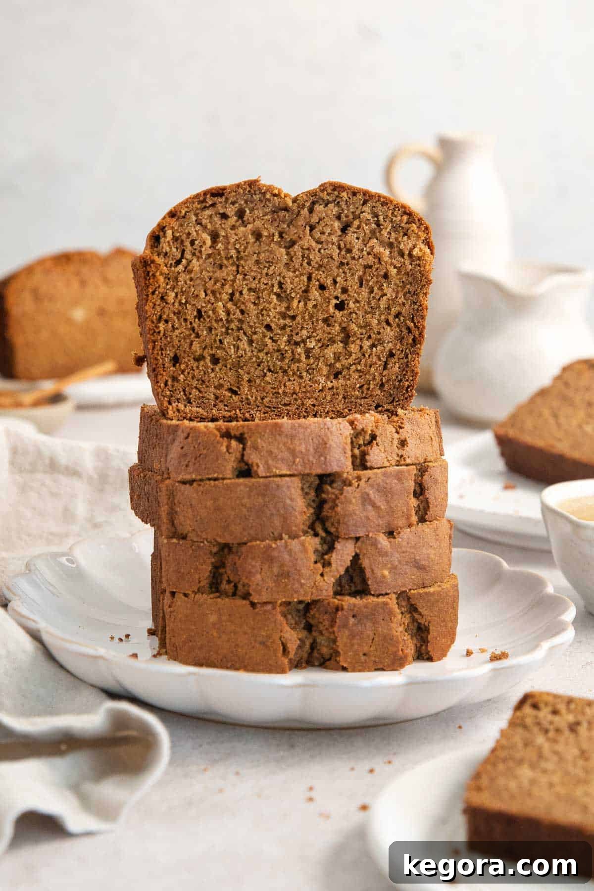 A stack of golden-brown applesauce bread slices, with one slice upright and facing the camera, showcasing its moist texture and apple chunks.