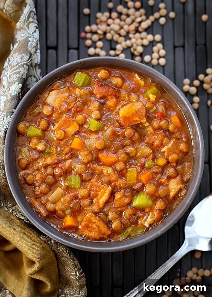 Lentil Soup in a gray bowl next to a silver spoon