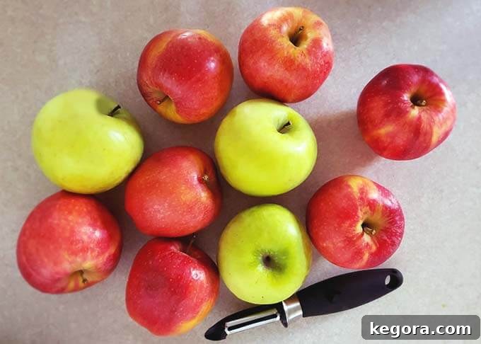 Quick Homemade Instant Pot Apple Butter 4 Several red and green apples next to a vegetable peeler