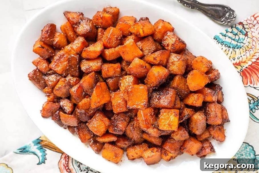 Maple Cinnamon Butternut Bliss 4 Top-down view of golden-brown Cinnamon Roasted Butternut Squash on a white platter, showcasing the caramelized edges
