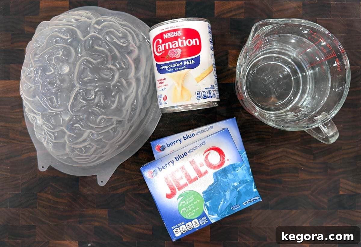 Ghoulish Jello Brain Recipe 4 Key ingredients for the Halloween Jello Brain Recipe laid out on a wooden board.