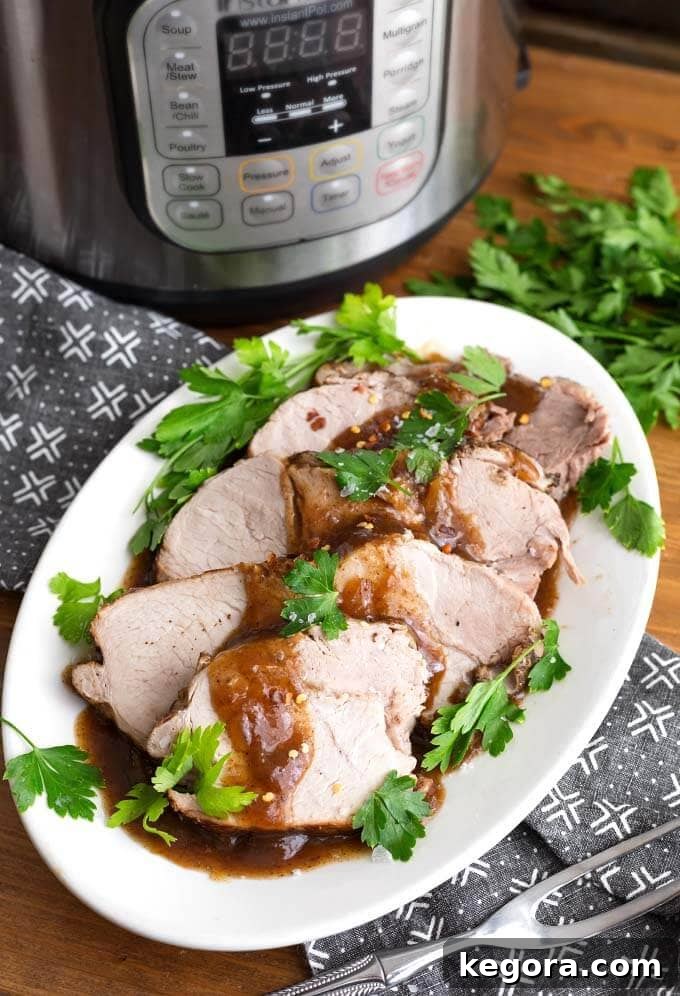 Balsamic Glazed Instant Pot Pork Loin 2 Sliced Balsamic Pork Loin Roast with fresh parsley on a white oblong platter in front of a pressure cooker