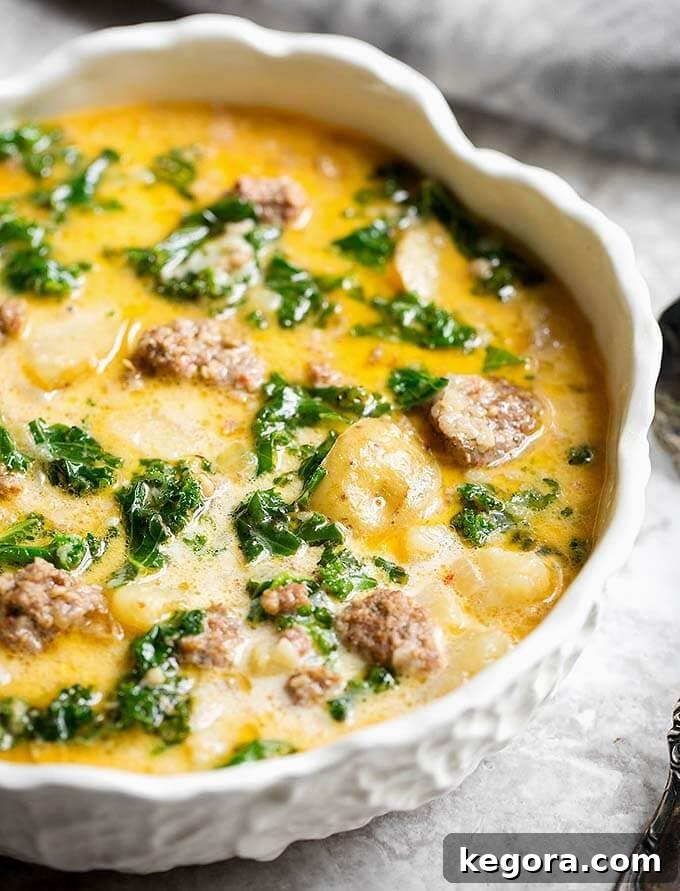 15 Delicious Instant Pot Soups 17 A comforting bowl of Instant Pot Zuppa Toscana (Sausage and Potato Soup), showcasing spicy sausage, tender potatoes, and vibrant kale in a rich, creamy broth, promising a hearty and flavorful meal.