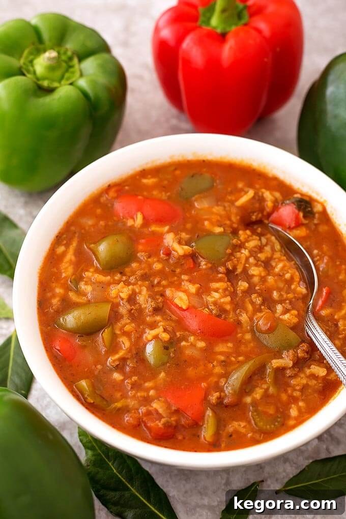 15 Delicious Instant Pot Soups 5 A comforting bowl of Instant Pot Stuffed Pepper Soup, complete with ground meat, rice, and tomato broth, garnished with fresh green peppers and herbs, capturing the essence of classic stuffed peppers.