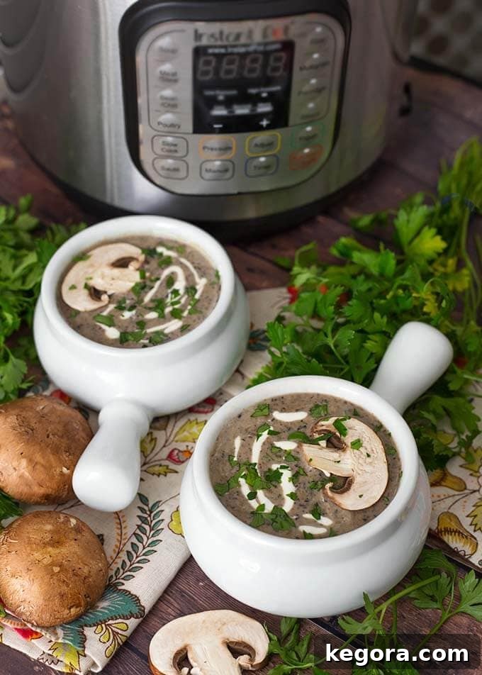 Two white handled bowls of rich Instant Pot Mushroom Soup ready to serve, surrounded by fresh parsley, whole mushrooms, and an electric pressure cooker in the background