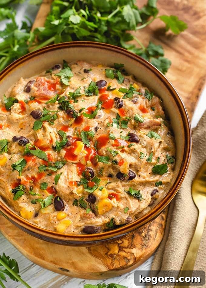 Creamy Chicken Chili in a beige bowl on a wooden board