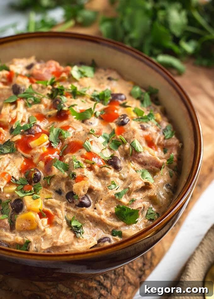 Creamy Chicken Chili in a beige bowl on a wooden board