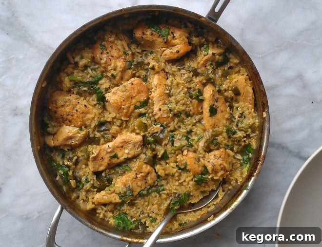 Delicious skillet chicken with Mexican green rice, ready to serve in a pan with a spoon
