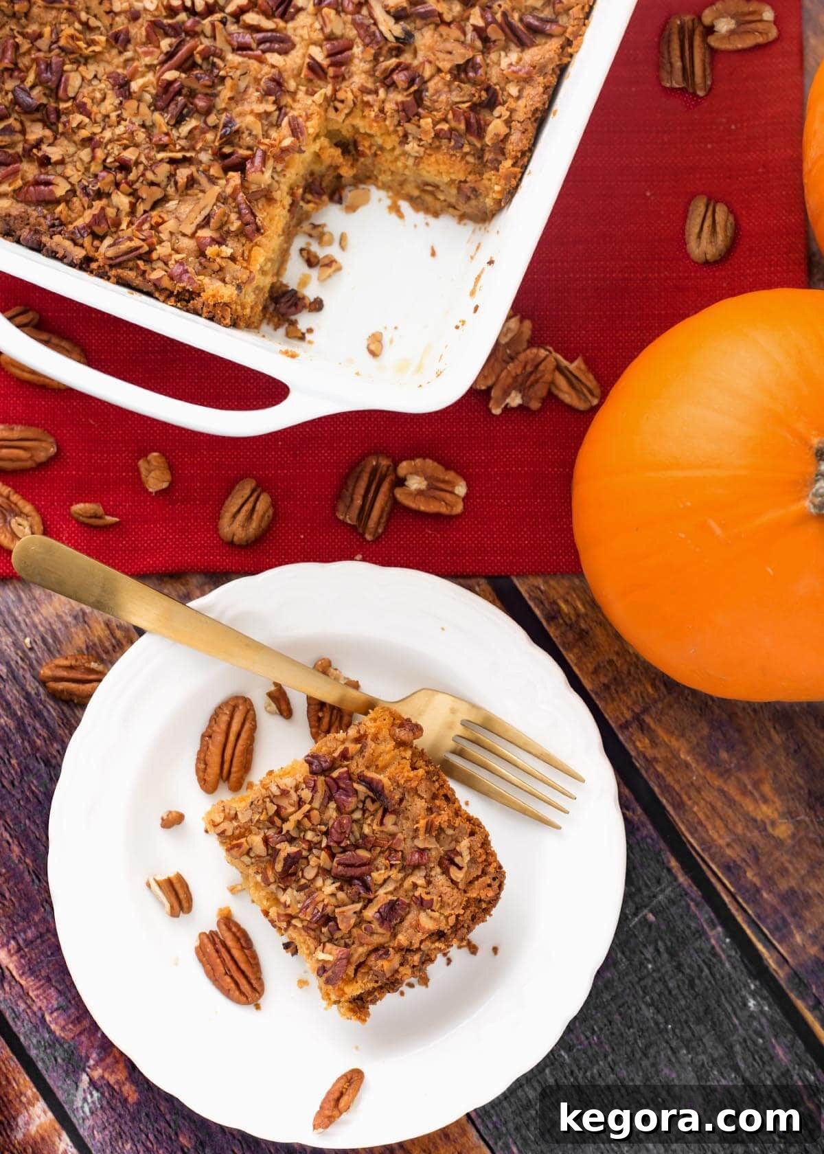 Autumn Spiced Pumpkin Crumble 3 Slice of Pumpkin Pie Dump Cake on a white plate with pecan halves, ready to be served