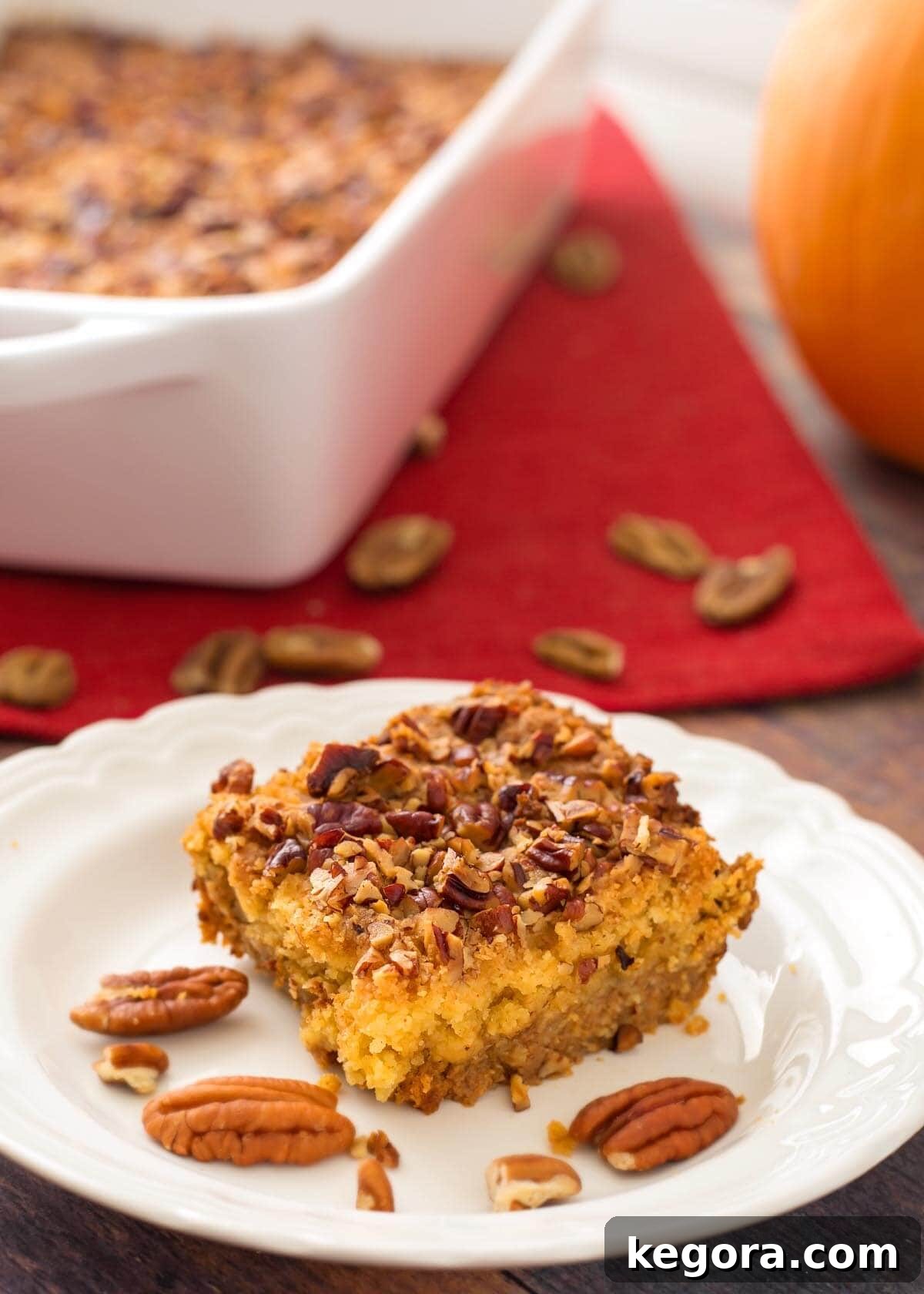 Autumn Spiced Pumpkin Crumble 7 Close-up slice of Pumpkin Pie Dump Cake on a white plate, showing the creamy pumpkin layer and crumbly topping