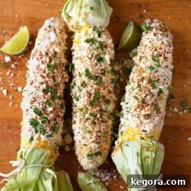 Three vibrant Mexican Street Corn (Elotes) on a rustic wooden board, ready to be enjoyed.