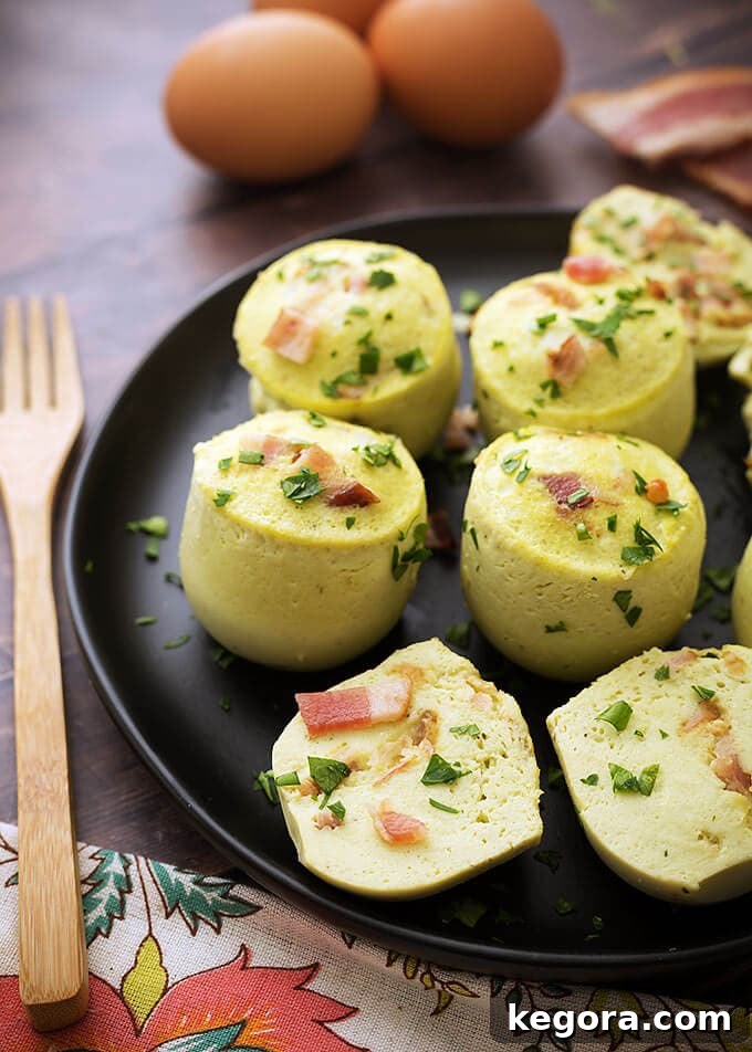 Fluffy Instant Pot Breakfast Bites 2 Several Instant Pot Egg Bites arranged beautifully on a black plate next to a wooden fork, showcasing their golden-brown edges and fluffy texture.